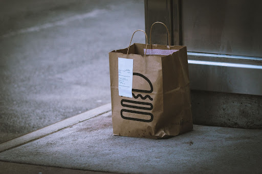 An image of a Shake Shack takeout bag dropped off at an apartment building.