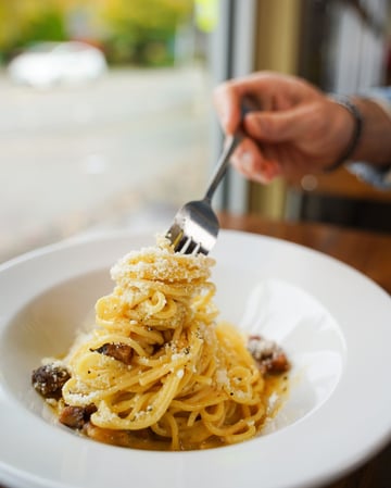 A photo of a customer eating Carbonara from Due' Cucina restaurant in Washington.